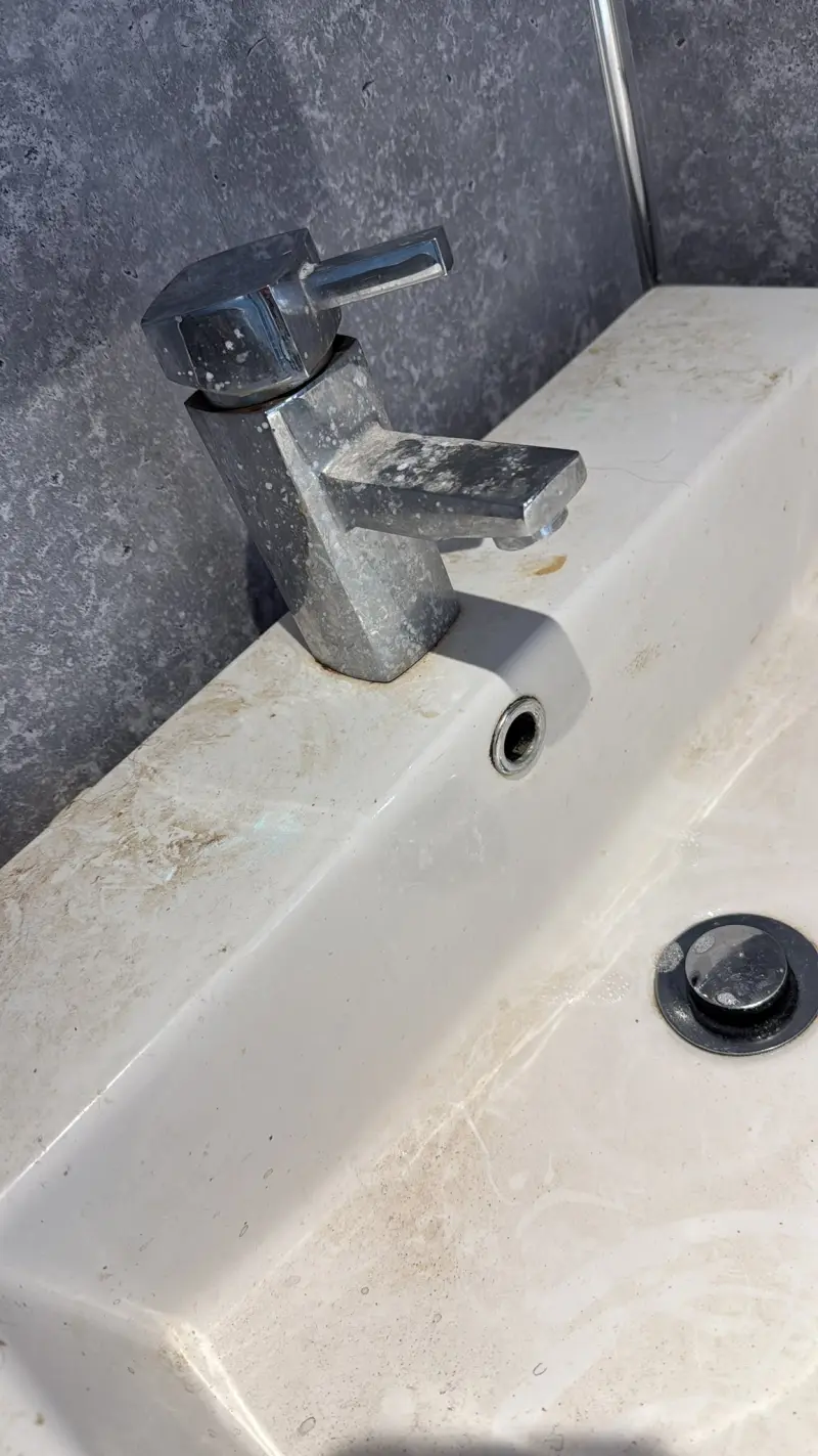 Sink with limescale buildup before cleaning